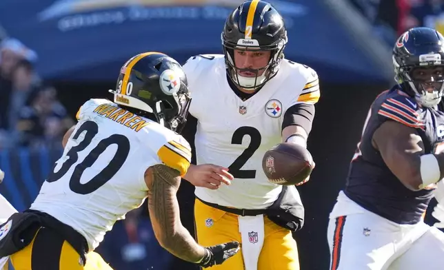 Pittsburgh Steelers quarterback Mason Rudolph (2) hands off to Jaylen Warren during the first half of an NFL football game against the Chicago Bears, Sunday, Nov. 23, 2025, in Chicago. (AP Photo/Nam Huh)