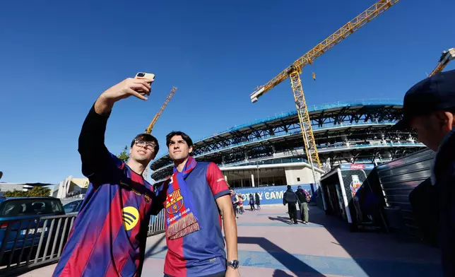 Fans stand in front of the renovedat Camp Nou stadium before La Liga soccer match between Barcelona and Athletic in Barcelona, Spain, Saturday, Nov. 22, 2025. AP Photo/Joan Monfort)