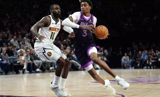 Minnesota Timberwolves forward Jaden McDaniels (3) works toward the basket as Denver Nuggets guard Tim Hardaway Jr. (10) defends during the first half of an NBA basketball game, Saturday, Nov. 15, 2025, in Minneapolis. (AP Photo/Abbie Parr)