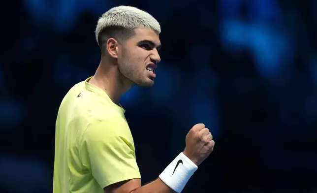 Spain's Carlos Alcaraz reacts after winning a point against Australia's Alex de Minaur during their singles tennis match of the ATP World Tour Finals, in Turin, Italy, Sunday, Nov. 9, 2025. (AP Photo/Antonio Calanni)