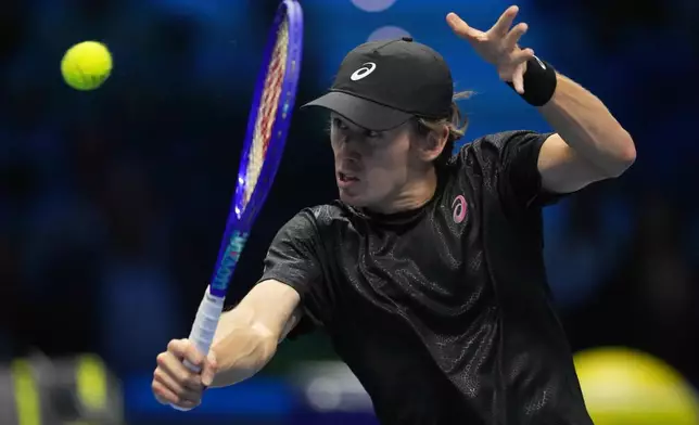 Australia's Alex de Minaur returns the ball to Spain's Carlos Alcaraz during their singles tennis match of the ATP World Tour Finals, in Turin, Italy, Sunday, Nov. 9, 2025. (AP Photo/Antonio Calanni)