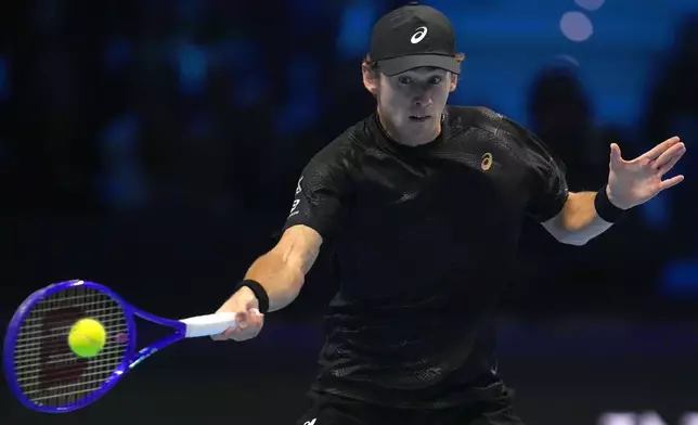 Australia's Alex de Minaur returns the ball to Spain's Carlos Alcaraz during their singles tennis match of the ATP World Tour Finals, in Turin, Italy, Sunday, Nov. 9, 2025. (AP Photo/Antonio Calanni)