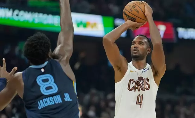 Cleveland Cavaliers center Evan Mobley (4) looks to shoot as Memphis Grizzlies forward Jaren Jackson Jr. (8) defends in the first half of an NBA basketball game Saturday, Nov. 15, 2025, in Cleveland. (AP Photo/Sue Ogrocki)