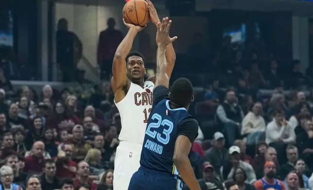 Cleveland Cavaliers forward De'Andre Hunter, left, goes up to shoot over Memphis Grizzlies forward Cedric Coward (23) in the first half of an NBA basketball game Saturday, Nov. 15, 2025, in Cleveland. (AP Photo/Sue Ogrocki)