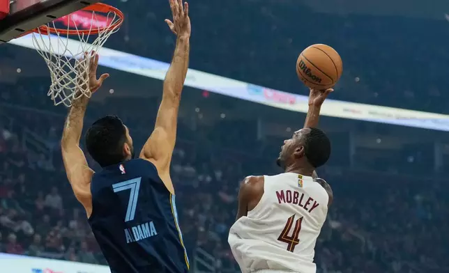Cleveland Cavaliers center Evan Mobley (4) shoots as Memphis Grizzlies forward Santi Aldama (7) defends in the first half of an NBA basketball game Saturday, Nov. 15, 2025, in Cleveland. (AP Photo/Sue Ogrocki)