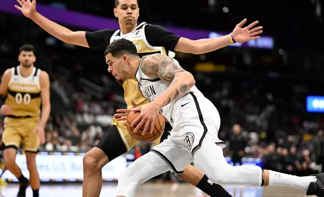 Brooklyn Nets forward Michael Porter Jr., bottom, collides with Washington Wizards forward Kyshawn George, top, during the second half of an NBA basketball game, Sunday, Nov. 16, 2025, in Washington. (AP Photo/John McDonnell)