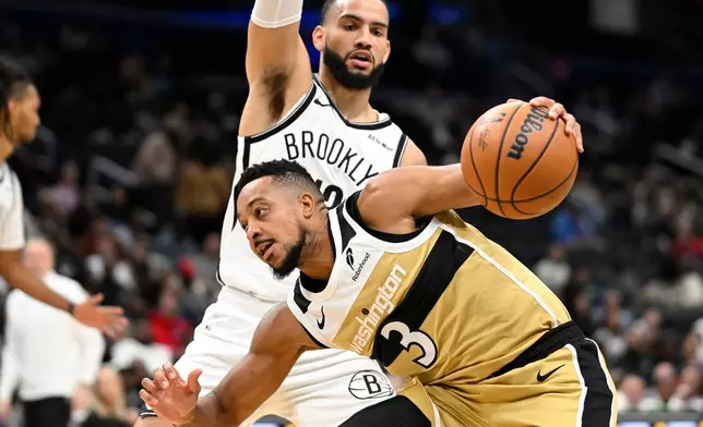 Washington Wizards guard CJ McCollum (3) drive the basket against Brooklyn Nets guard Tyrese Martin during the first half of an NBA basketball game, Sunday, Nov. 16, 2025, in Washington. (AP Photo/John McDonnell)