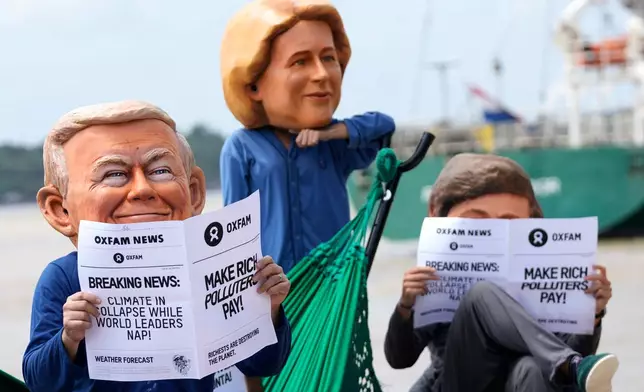 Oxfam activists wear puppet heads in the likeness of U.S. President Donald Trump, left, President of the European Commission Ursula von der Leyen, center, and President of Argentina Javier Milei as they protest ahead of the COP30 U.N. Climate Summit in Belem, Para state, Brazil, Wednesday, Nov. 5, 2025. (AP Photo/Eraldo Peres)