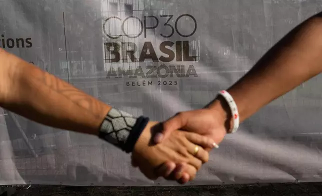 Indigenous people hold hands during a demonstration in defense of the Amazon during the COP30 U.N. Climate Summit, in Belem, Para state, Brazil, Thursday, Nov. 6, 2025. (AP Photo/Eraldo Peres)