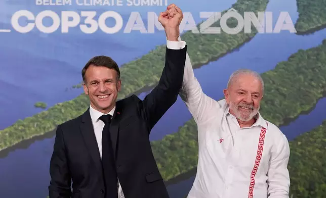 Brazil's President Luiz Inacio Lula da Silva, right, and France President Emmanuel Macron pose for photos after meeting during the COP30 U.N. Climate Summit, in Belem, Brazil, Thursday, Nov. 6, 2025. (AP Photo/Eraldo Peres)
