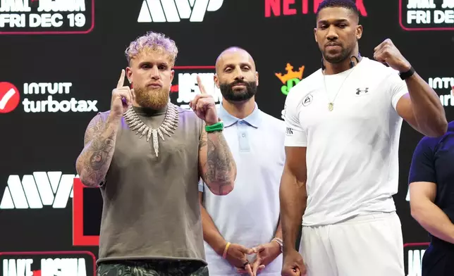 Jake Paul, left, and Anthony Joshua, right, pose 04during a news conference promoting their upcoming heavyweight boxing match, Friday, Nov. 21, 2025, in Miami. (AP Photo/Lynne Sladky)
