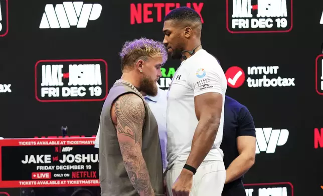 Jake Paul, left, and Anthony Joshua, right, face off during a news conference, Friday, Nov. 21, 2025, in Miami, promoting their upcoming heavyweight boxing match. (AP Photo/Lynne Sladky)