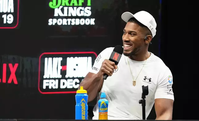 Anthony Joshua speaks during a news conference with Jake Paul promoting their upcoming heavyweight boxing match, Friday, Nov. 21, 2025, in Miami. (AP Photo/Lynne Sladky)
