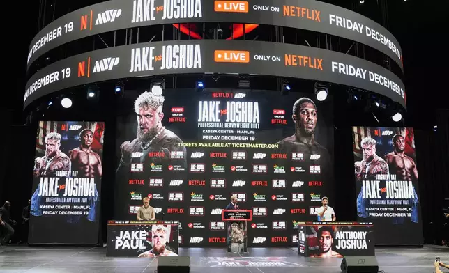 Jake Paul, left, and Anthony Joshua, right, are on stage during a news conference promoting their upcoming heavyweight boxing match Friday, Nov. 21, 2025, in Miami. (AP Photo/Lynne Sladky)