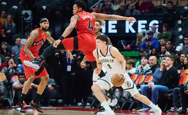 Brooklyn Nets' Egor Dëmin (8) drives past Toronto Raptors' Scottie Barnes (4) during first half NBA basketball action in Toronto, on Sunday, Nov. 23, 2025. (Sammy Kogan/The Canadian Press via AP)