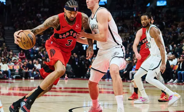 Toronto Raptors' Brandon Ingram (3) drives through Brooklyn Nets' Egor Dëmin (8) during first half NBA basketball action in Toronto, on Sunday, Nov. 23, 2025. (Sammy Kogan/The Canadian Press via AP)