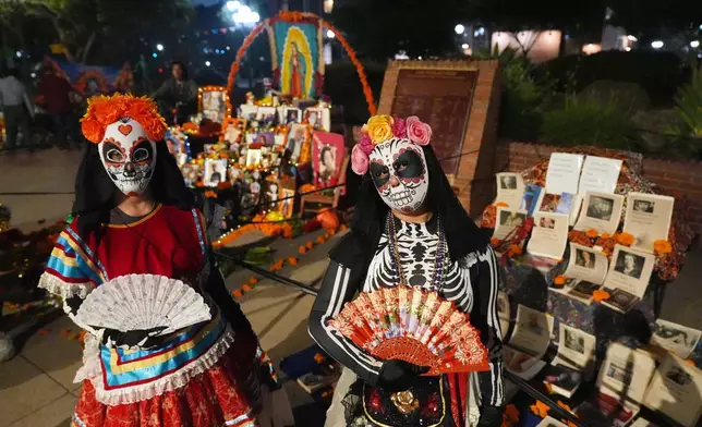 People join Olvera Street merchants in a night procession during the Day of the Death festival, Sunday, Oct. 26, 2025, in Los Angeles. (AP Photo/Damian Dovarganes)