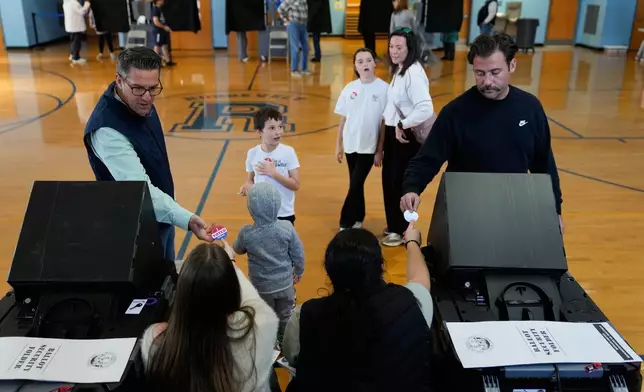 Voters receive stickers after voting at a polling site in River Edge, N.J., Tuesday, Nov. 4, 2025. (AP Photo/Seth Wenig)