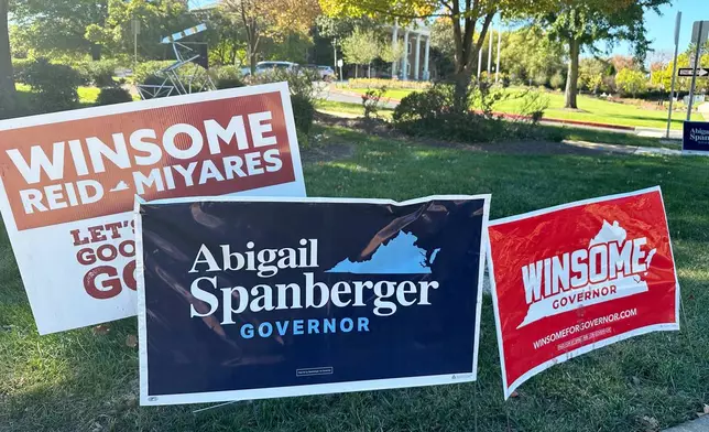 Campaign signs for Virginia gubernatorial nominees Democrat Abigail Spanberger and Republican Winsome Earle-Sears are on display outside City Hall in Fairfax, Va., Friday, Oct. 17, 2025. (AP Photo/Robert Yoon)