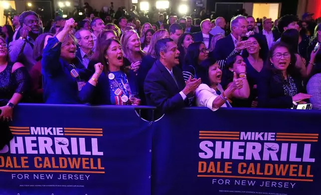 Supporters at New Jersey Democratic gubernatorial candidate Mikie Sherrill's election night party cheer as early results are seen in East Brunswick, N.J., Tuesday, Nov. 4, 2025. (AP Photo/Matt Rourke)