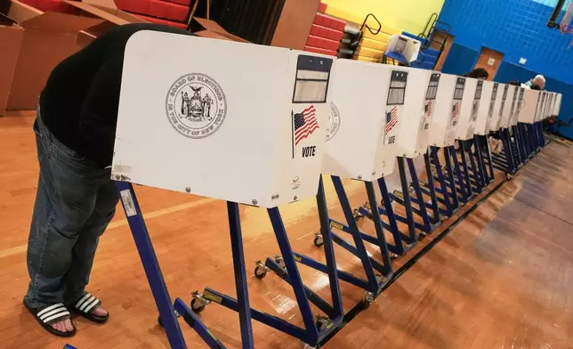 A voter marked his ballot at a voting site, in New York, Tuesday, Nov. 4, 2025. (AP Photo/Richard Drew)