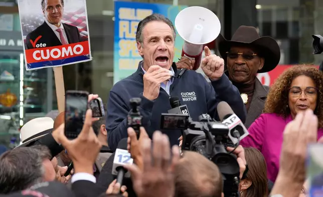 New York City mayoral candidate Andrew Cuomo speaks to a crowd of reporters and pedestrians while campaigning in New York, Monday, Nov. 3, 2025. (AP Photo/Seth Wenig)