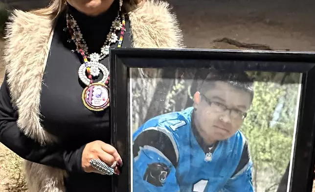 Vangie Randall-Shorty holds up a photograph of her son Zachariah Shorty during a stop in Bernalillo, N.M., on Nov. 24, 2025. (AP Photo/Susan Montoya Bryan)