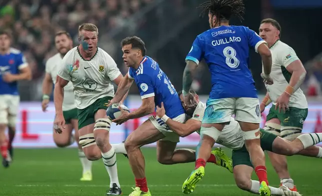 France's Damian Penaud is tackled during the rugby union Nations Series match between France and South Africa in Saint-Denis, outside Paris, Saturday, Nov. 8, 2025 . (AP Photo/Michel Euler)