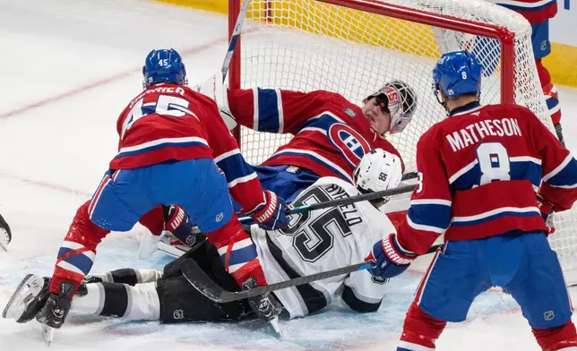 Montreal Canadiens goaltender Sam Montembeault (35) loses his mask as Los Angeles Kings' Quinton Byfield (55) slides into him during first period NHL hockey action in Montreal on Tuesday, Nov. 11, 2025. (Christinne Muschi/The Canadian Press via AP)