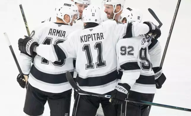 Los Angeles Kings' Joel Edmundson (6) celebrates his goal over Montreal Canadiens with teammates Brandt Clarke (92), Anze Kopitar (11), Joel Armia (40) and Adrian Kempe (9) during second period NHL hockey action in Montreal on Tuesday, Nov. 11, 2025. (Christinne Muschi/The Canadian Press via AP)