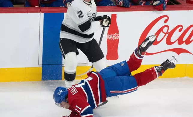 Montreal Canadiens' Brendan Gallagher (11) is tripped up in front of Los Angeles Kings' Brian Dumoulin (2) during the third period of an NHL hockey game, in Montreal, Tuesday, Nov. 11, 2025. (Christinne Muschi/The Canadian Press via AP)
