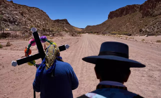 Cipriana Soriano, right, and Mercedes Soriano return to their house after visiting the tomb of their loved ones during Day of the Dead celebration in Susques, Jujuy province, Argentina, Saturday, Nov. 1, 2025. (AP Photo/Rodrigo Abd)