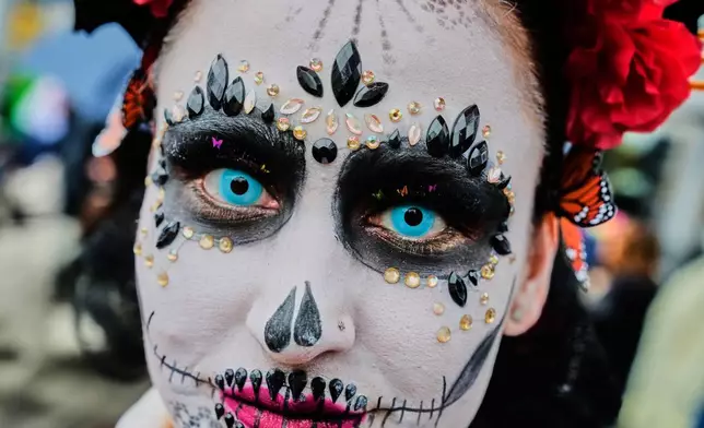 A woman attends the traditional Catrina parade marking the Day of the Dead in Frankfurt, Germany, Saturday, Nov. 1, 2025. (AP Photo/Michael Probst)