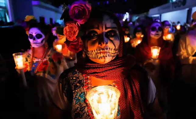People with skull make up march during the Paseo de las Animas parade as part of the Day of the Dead celebrations in Merida, Mexico, Friday, Oct. 31, 2025. (AP Photo/Martin Zetina)