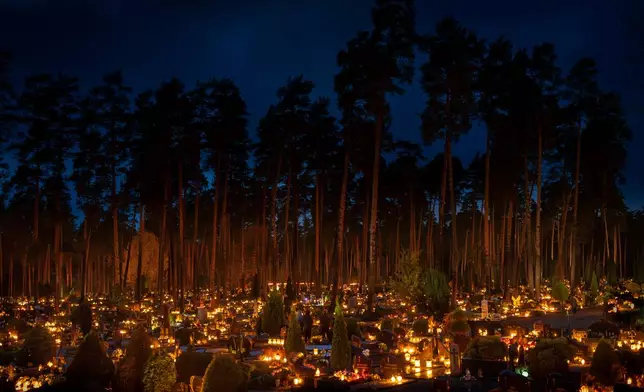 Candles are lit during All Saints Day at the cemetery in Vilnius, Lithuania, Saturday, Nov. 1, 2025. (AP Photo/Mindaugas Kulbis)