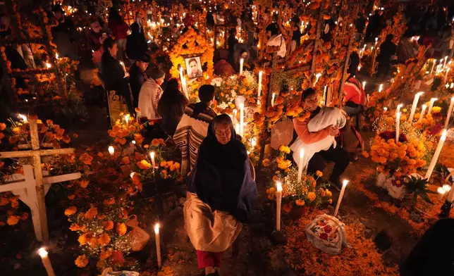 Families gather to keep company with their dearly departed celebrating the Day of the Dead at the cemetery in Arocutin, Michoacan state, Mexico, Saturday, Nov. 1, 2025. (AP Photo/Eduardo Verdugo)