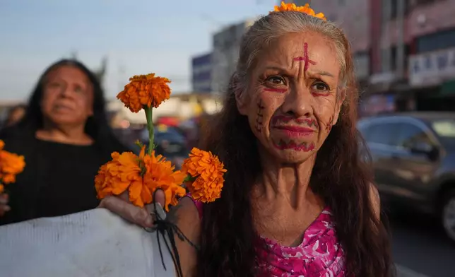Women take part in a march honoring deceased sex workers ahead of the Day of the Dead celebrations in Mexico City, Friday, Oct. 31, 2025. (AP Photo/Claudia Rosel)