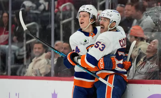 New York Islanders center Calum Ritchie, left, celebrates with center Casey Cizikas after scoring during the first period of an NHL hockey game against the Detroit Red Wings, Thursday, Nov. 20, 2025, in Detroit. (AP Photo/Ryan Sun)