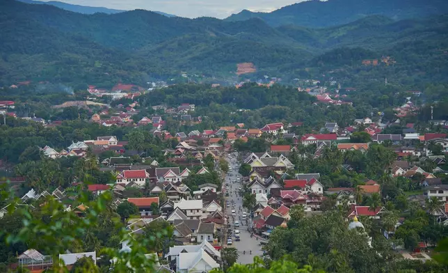 A view traditional homes and temples beneath forested mountains in Luang Prabang, Laos, Wednesday, Nov. 5, 2025. (AP Photo/Eugene Hoshiko)