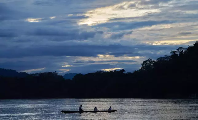 A longtail boat crosses the Mekong River at sunset under heavy clouds in Luang Prabang, Laos, Monday, Nov. 3, 2025. (AP Photo/Eugene Hoshiko)