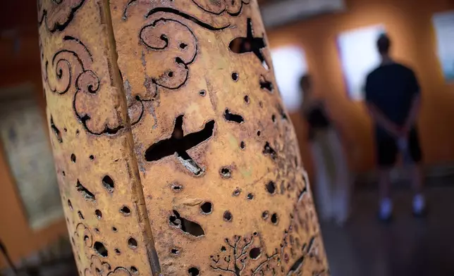 Metal artwork engraved with wartime scenes is seen created from remnants of unexploded ordnance found during clearance operations, displayed at the UXO Lao Visitor Center in Luang Prabang, Laos, Monday, Nov. 3, 2025. (AP Photo/Eugene Hoshiko)