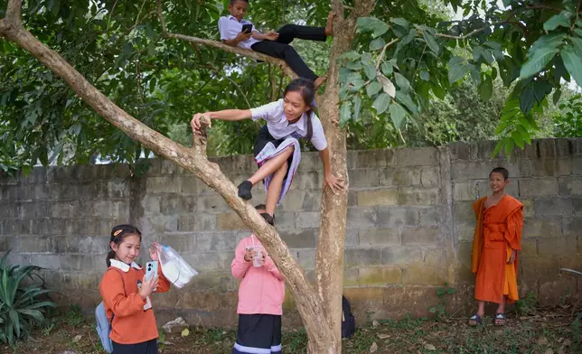 Students from an elementary school, including a novice Buddhist monk, play after class in Luang Prabang, Laos, Tuesday, Nov. 4, 2025. (AP Photo/Eugene Hoshiko)