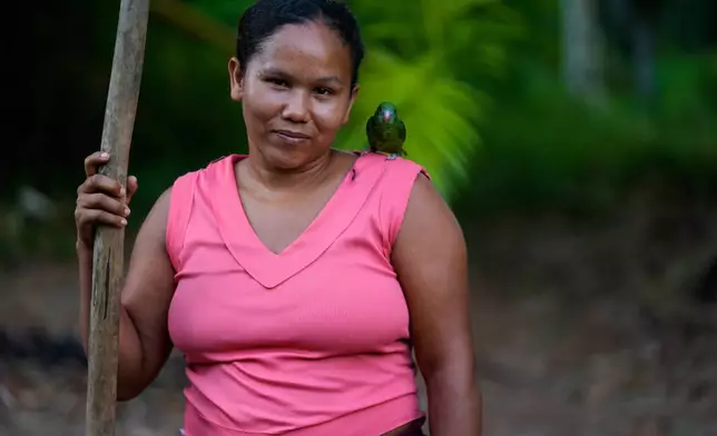 Adria poses for a photo with her little mascot at the backyard of her home in Itacoa Miri, Brazil, Tuesday, Nov. 18, 2025. (AP Photo/Fernando Llano)