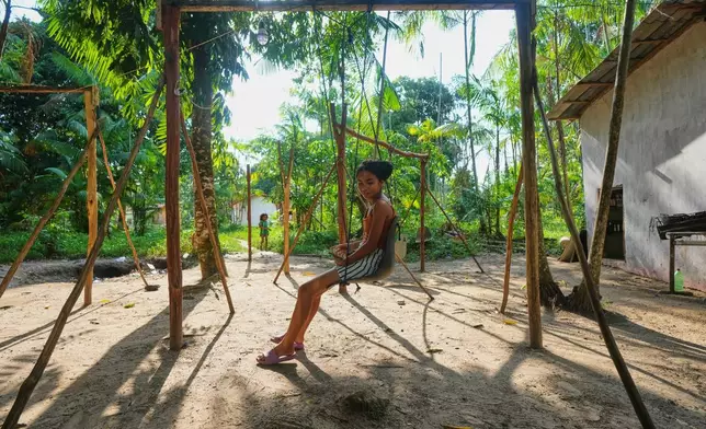 A girl plays in a park in Itacoa Miri, Brazil, Tuesday, Nov. 18, 2025. (AP Photo/Fernando Llano)