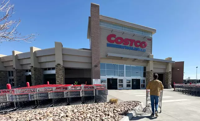 FILE - A lone shopper pushes a cart toward the entrance of a Costco warehouse, March 13, 2025, in Sheridan, Colo. (AP Photo/David Zalubowski, File)