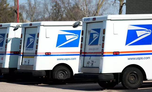 FILE - U.S. Postal Service trucks park outside a post office, Jan. 29, 2024, in Wheeling, Ill. (AP Photo/Nam Y. Huh, File)