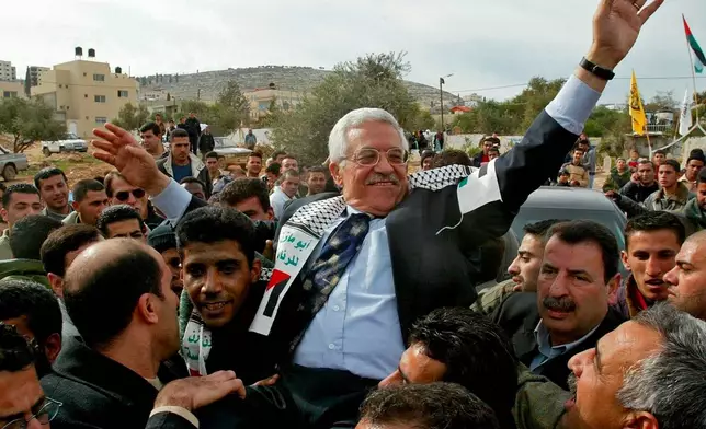 FILE - Interim Palestinian leader Mahmoud Abbas, is carried by the Al Aqsa Martyrs' Brigades leader in West Bank, Zakaria Zubeidi, center left, during a campaign visit to the Jenin refugee camp Dec. 30, 2004.(AP Photo/Enric Marti, File)