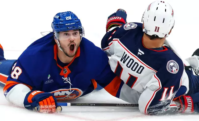 New York Islanders defenseman Alexander Romanov (28) reacts after being called for a hooking penalty against Columbus Blue Jackets left wing Miles Wood (11) during the third period of an NHL hockey game Sunday, Nov. 2, 2025, in New York. (AP Photo/Noah K. Murray)