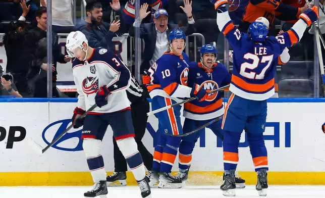 Columbus Blue Jackets center Charlie Coyle (3) skates to the bench as New York Islanders Anders Lee (27) and Jean-Gabriel Pageau, celebrate after a goal by Simon Holmstrom (10) during the third period of an NHL hockey game against the Columbus Blue Jackets, Sunday, Nov. 2, 2025, in New York. (AP Photo/Noah K. Murray)