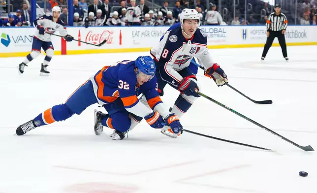New York Islanders center Kyle MacLean (32) battles Columbus Blue Jackets defenseman Zach Werenski (8) for the puck during the first period of an NHL hockey game, Sunday, Nov. 2, 2025, in New York. (AP Photo/Noah K. Murray)